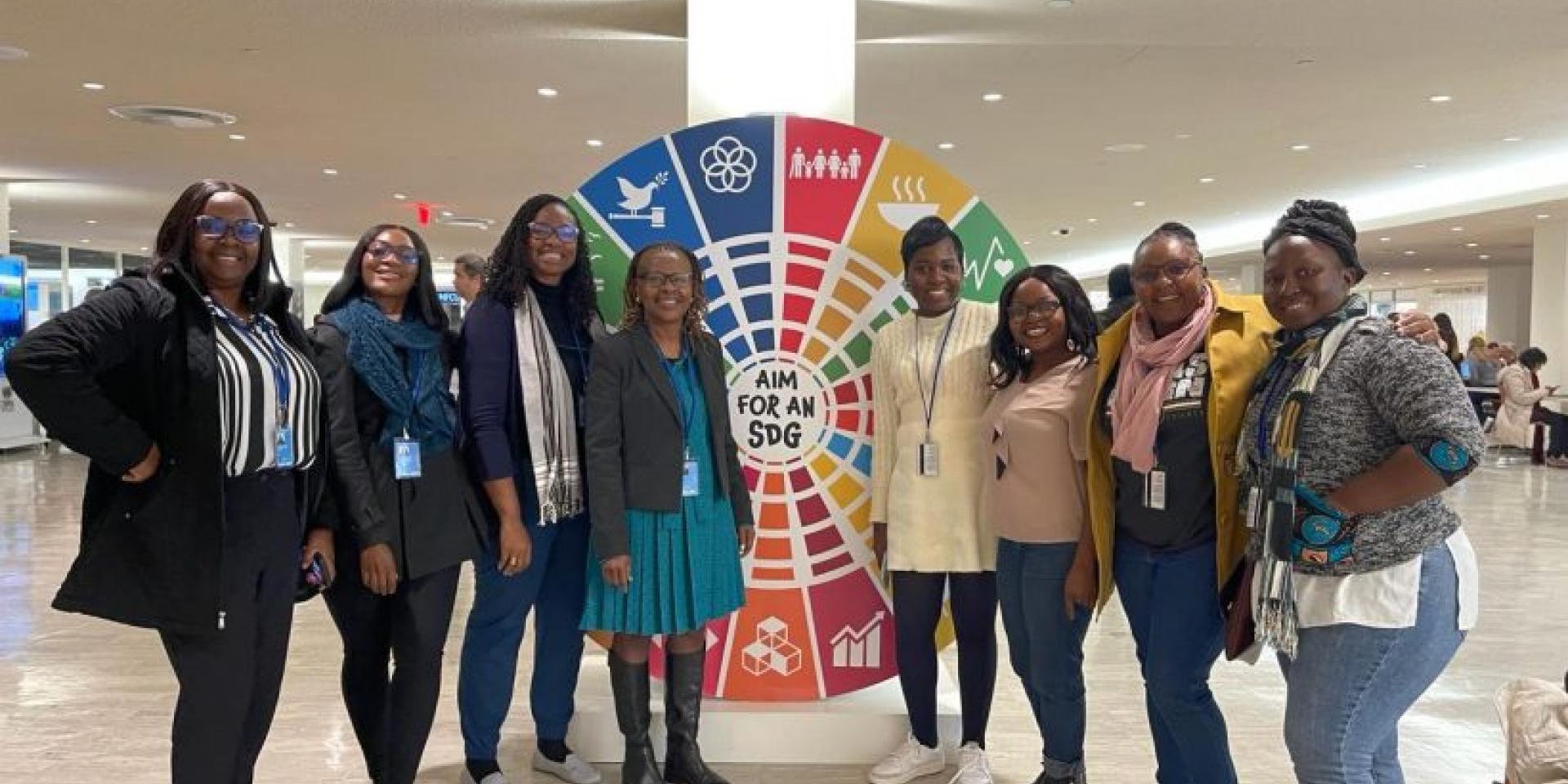 Group of women standing in front of SDG banner