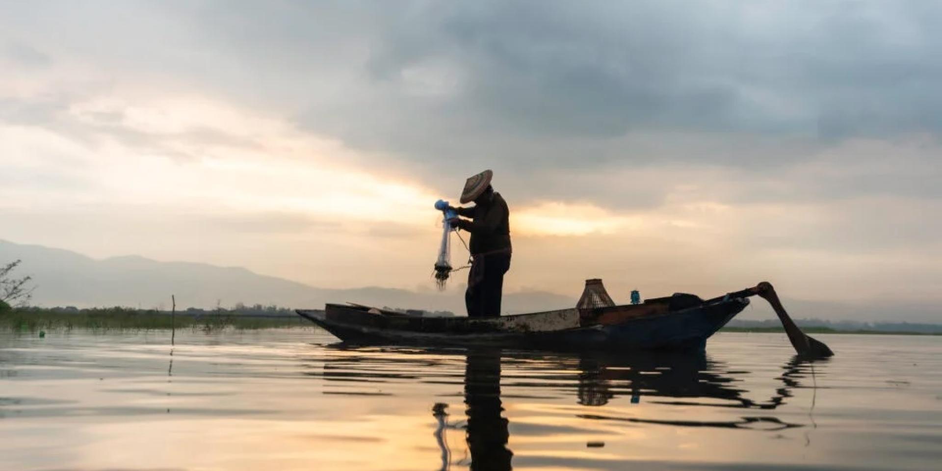 Photo of a fisherman fishing at sunset