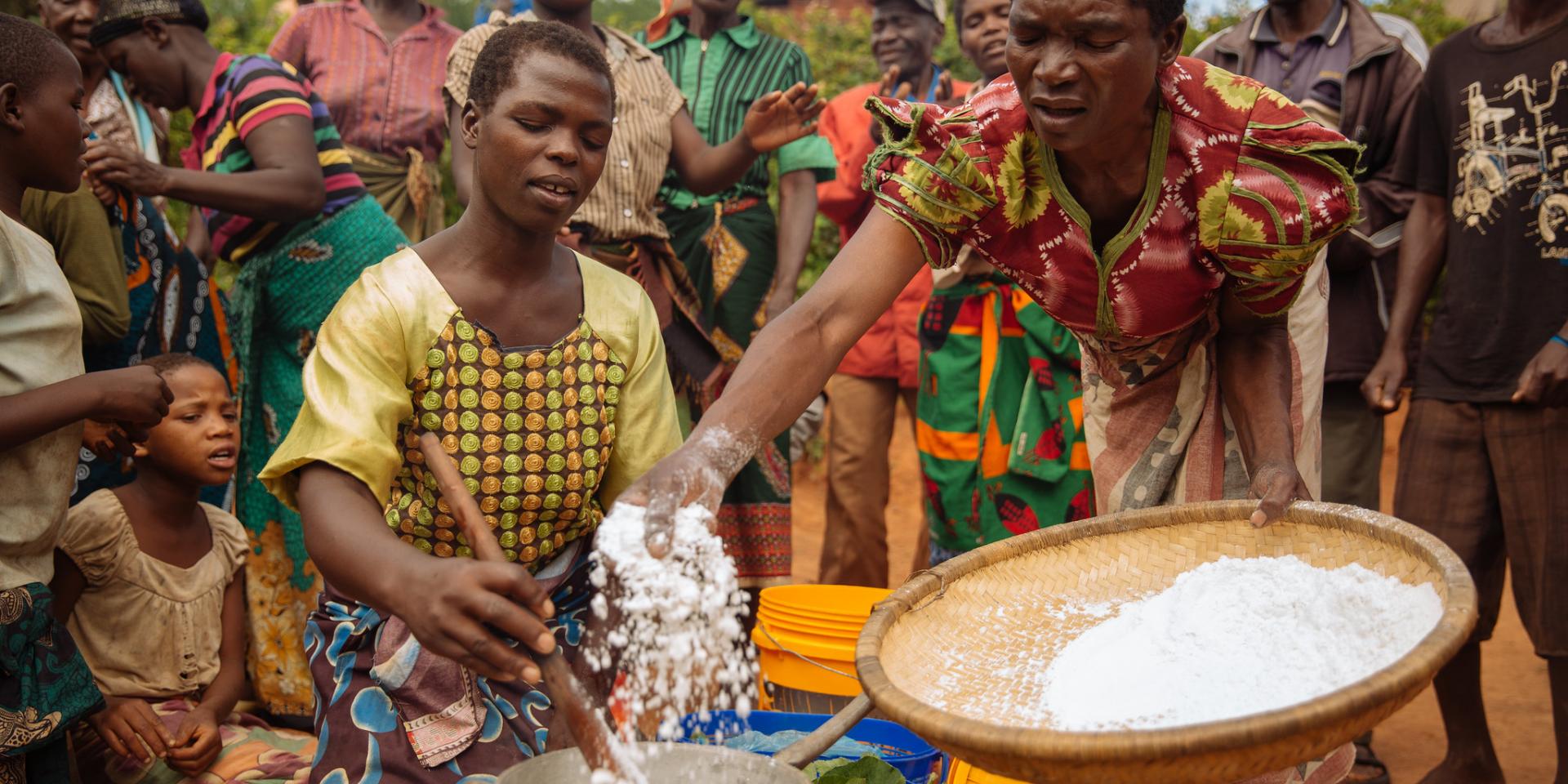 Malawi Women Preparing a Meal with Neighbors Gathered