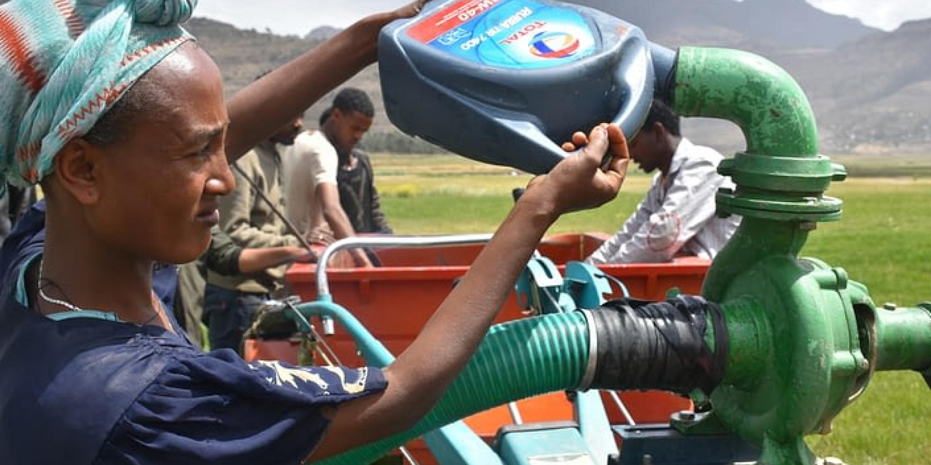 A woman filling a machine with petrol