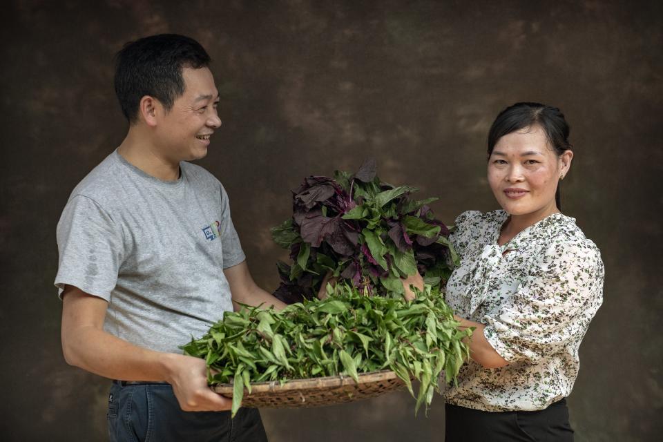 A man and a woman carrying vegetables