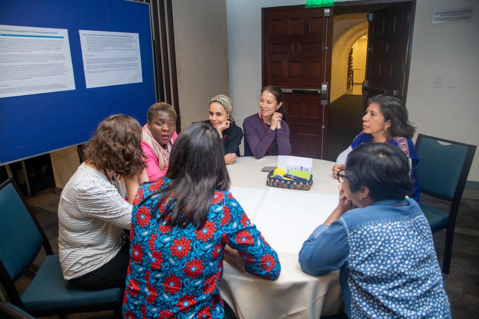 Photo of researchers round a table in a workshop