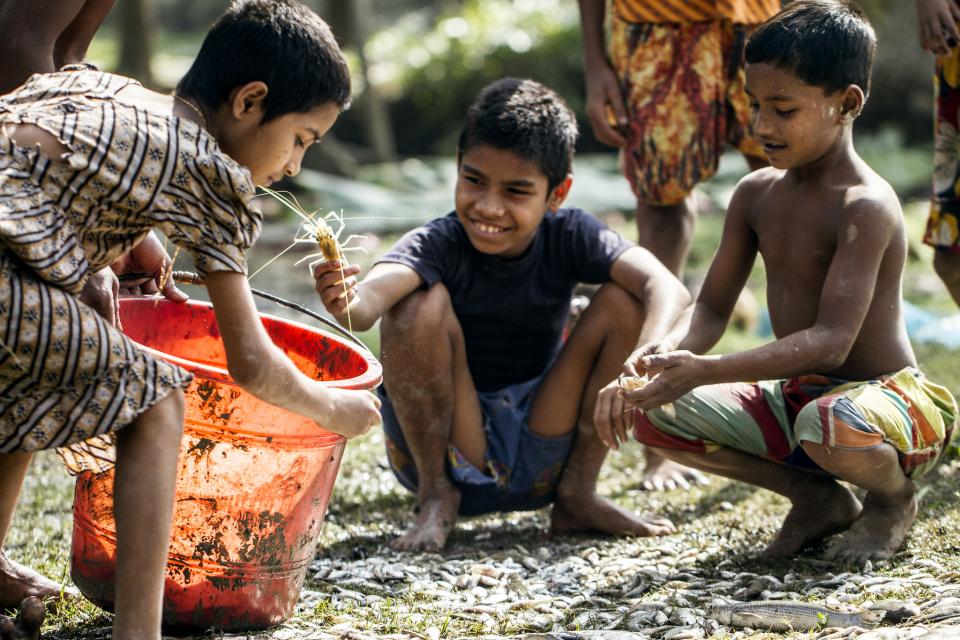 Boys outside with buckets of water.